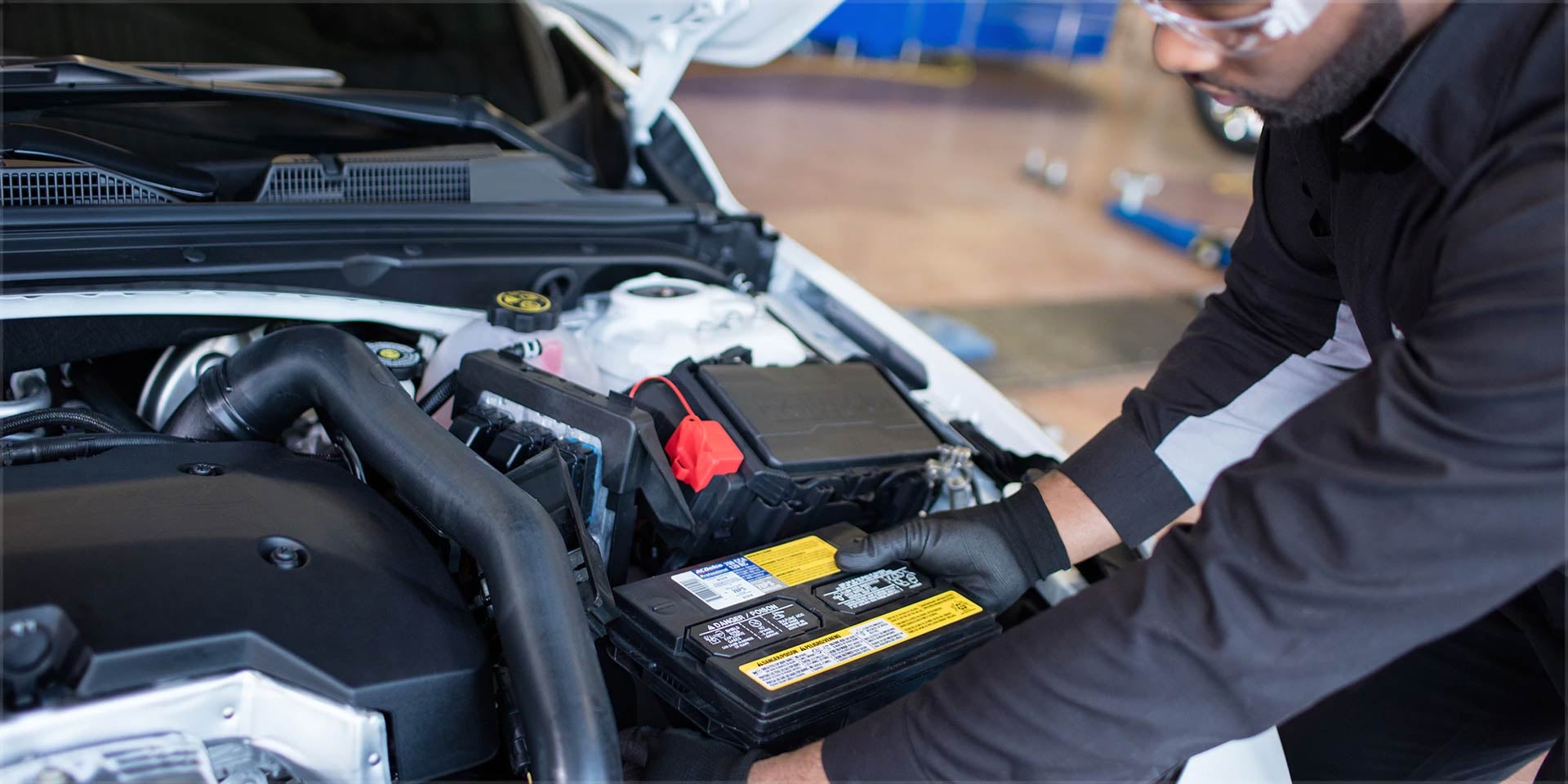 A mechanic fitting battery into car