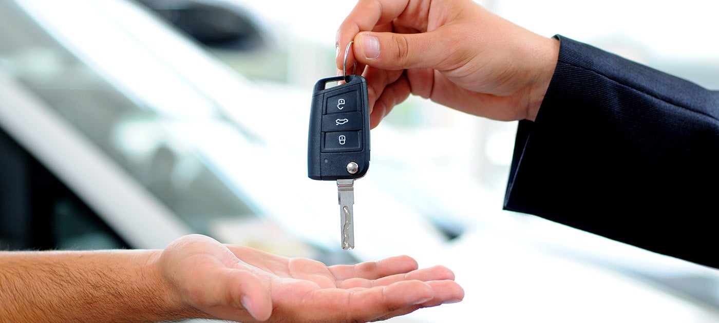A salesperson handovering a key to customer