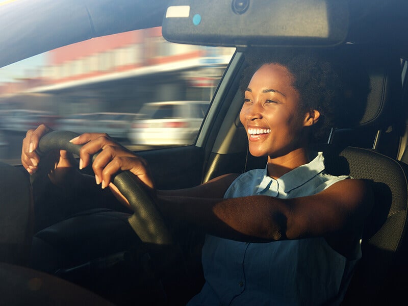 A swomen is driving a car
